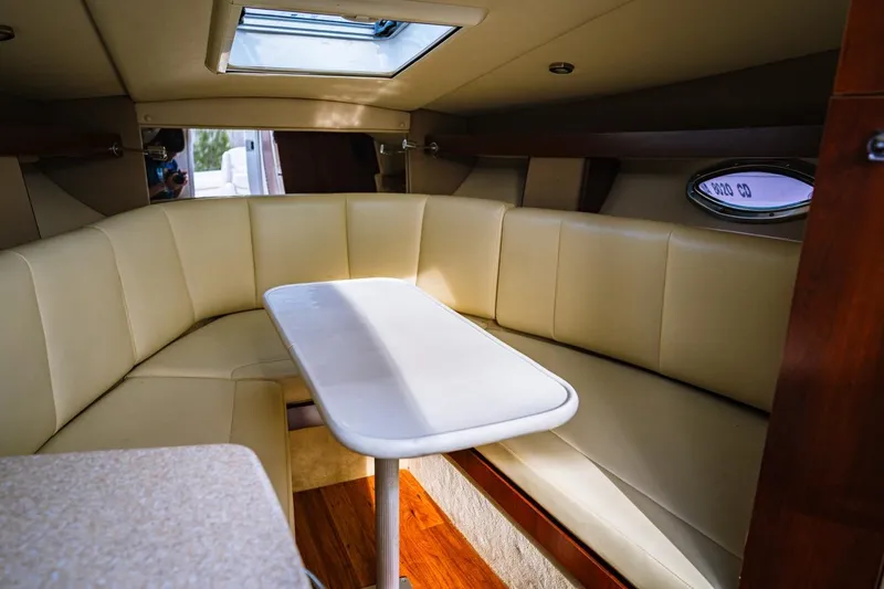 Slide: The Image of Interior of 2018 Chaparral 270 Signature boat with beige seating and table. - 4