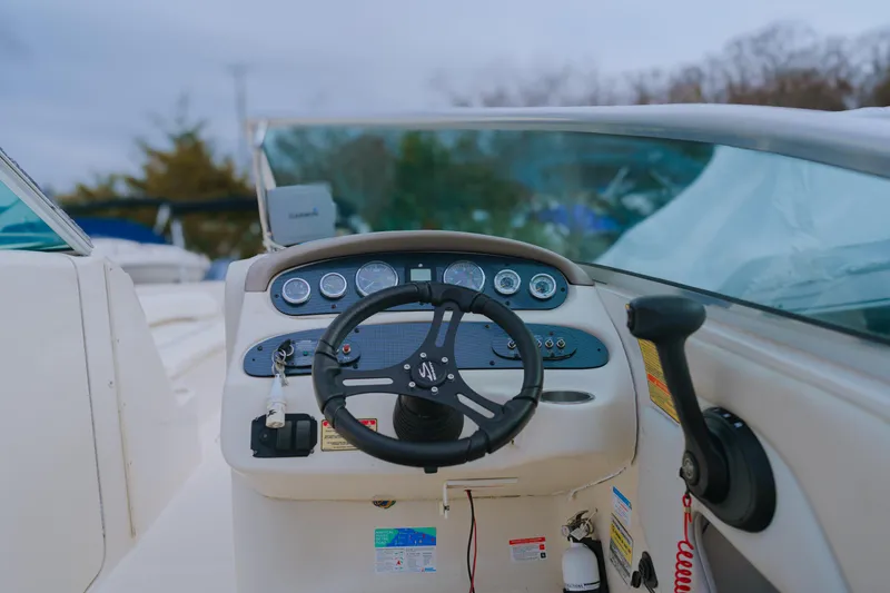 Slide: The Image of 2003 Sea Ray 240 Sundeck boat dashboard with steering wheel and controls. - 6