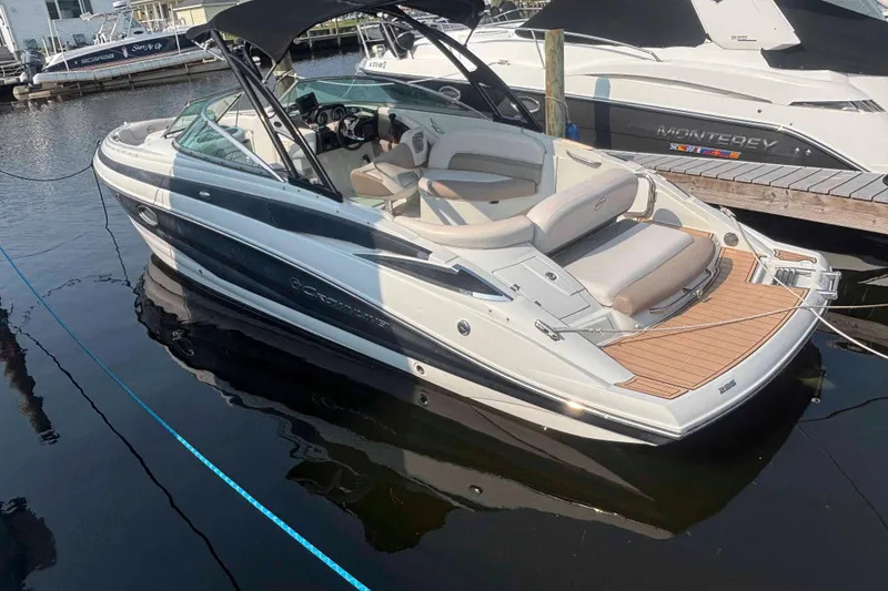 Slide: The Image of 2014 Crownline 285 SS boat docked, featuring sleek design and spacious seating. - 1