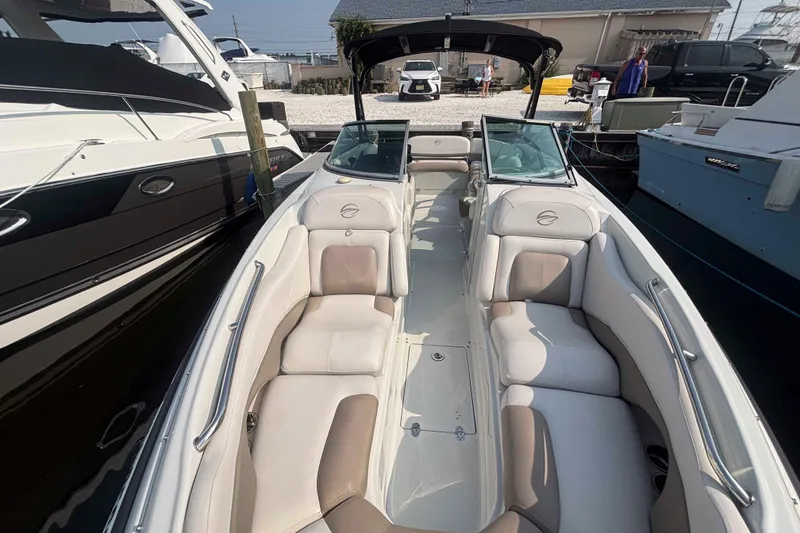 Slide: The Image of 2014 Crownline 285 SS boat with spacious seating and sleek design at a marina. - 11