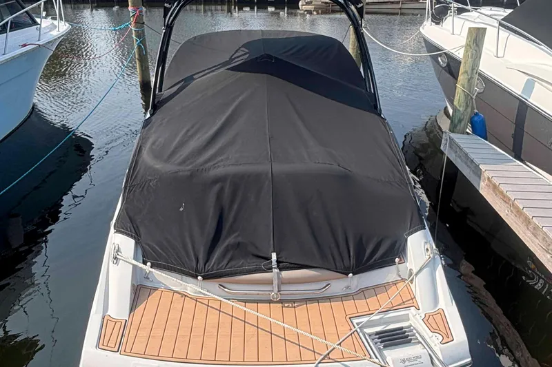 Slide: The Image of 2014 Crownline 285 SS boat docked with black cover, rear view. - 15