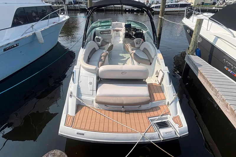 Slide: The Image of 2014 Crownline 285 SS boat docked, featuring spacious seating and sleek design. - 2