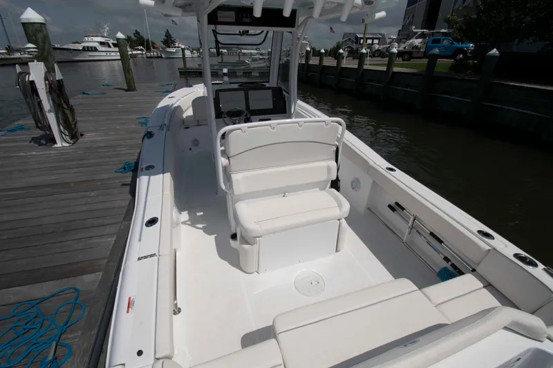 Slide: The Image of 2023 Sea Hunt Ultra 265 SE boat interior at dock, featuring seating and console. - 12