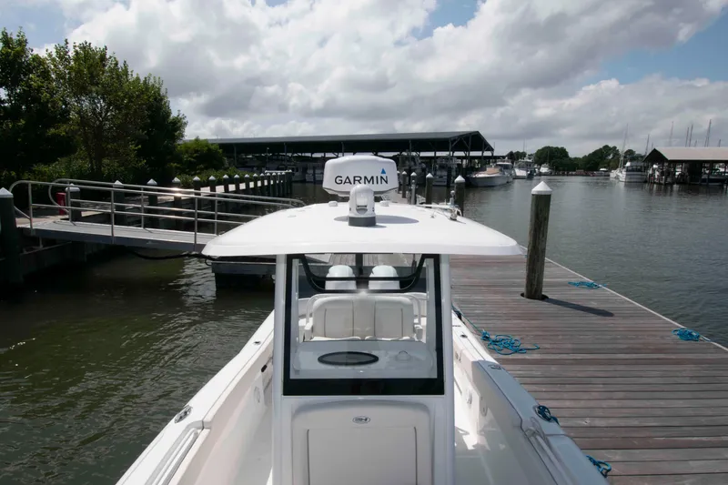 Slide: The Image of 2023 Sea Hunt Ultra 265 SE boat docked at marina under cloudy sky. - 14