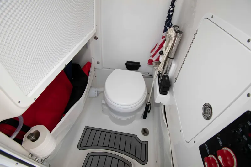 Slide: The Image of 2023 Sea Hunt Ultra 265 SE boat interior with toilet and storage. - 19