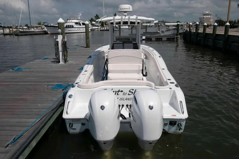 Slide: The Image of 2023 Sea Hunt Ultra 265 SE boat docked at marina with twin engines. - 2