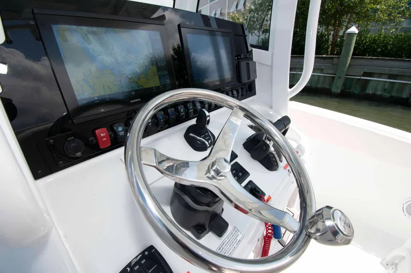 Slide: The Image of 2023 Sea Hunt Ultra 265 SE boat dashboard with steering wheel and navigation screens. - 9