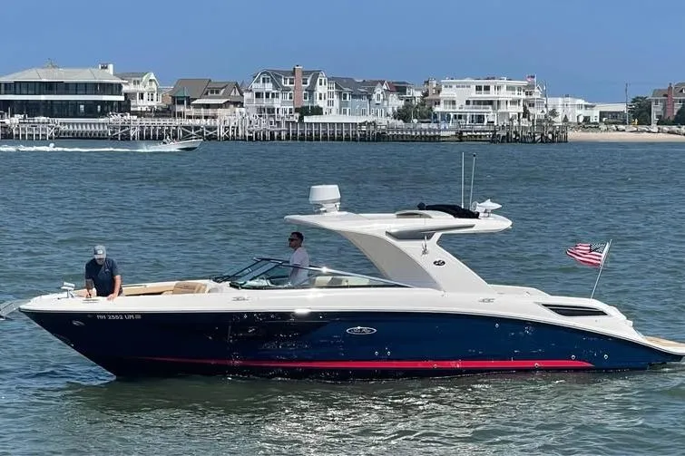 Slide: The Image of 2019 Sea Ray SLX 350 boat cruising on water near coastal homes. - 0