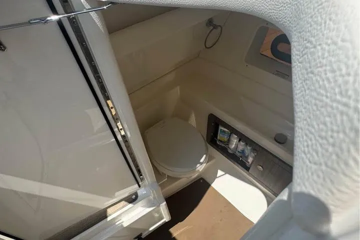 Slide: The Image of 2019 Sea Ray SLX 350 boat interior with compact bathroom and storage. - 11