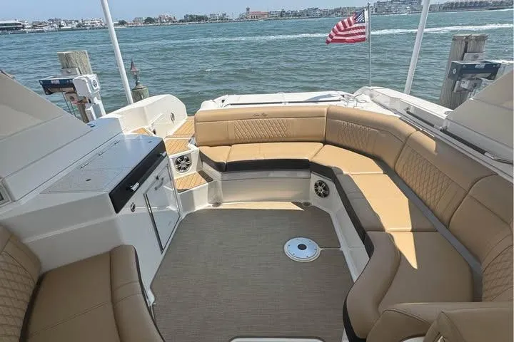 Slide: The Image of Luxurious 2019 Sea Ray SLX 350 boat interior with tan seating and waterfront view. - 2