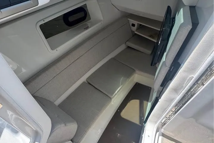 Slide: The Image of 2019 Sea Ray SLX 350 cabin interior with gray seating and storage shelves. - 9