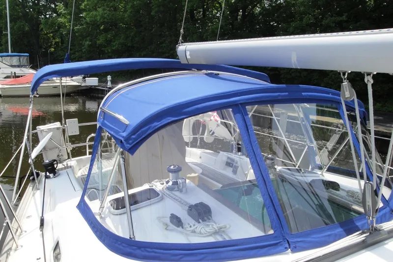 Slide: The Image of 2006 Beneteau Oceanis Clipper 423 sailboat with blue canopy docked in a marina. - 11