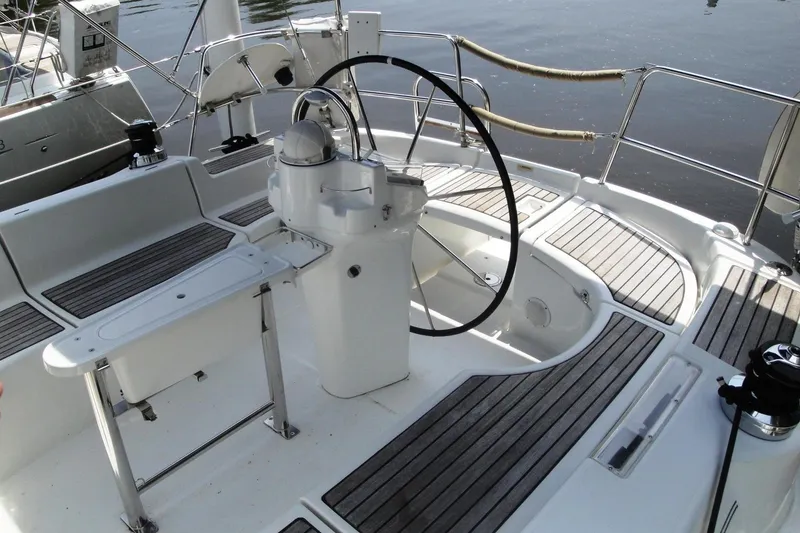 Slide: The Image of 2006 Beneteau Oceanis Clipper 423 yacht cockpit with steering wheel and wooden deck. - 13