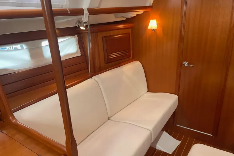 Slide: The Image of Interior of 2006 Beneteau Oceanis Clipper 423 with white seating and wooden finishes. - 19
