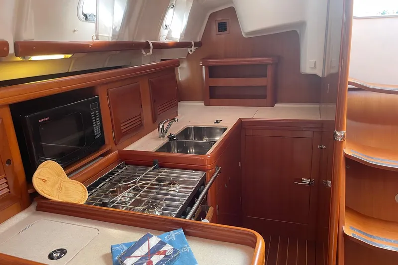 Slide: The Image of 2006 Beneteau Oceanis Clipper 423 yacht kitchen with stove, sink, and microwave. - 22