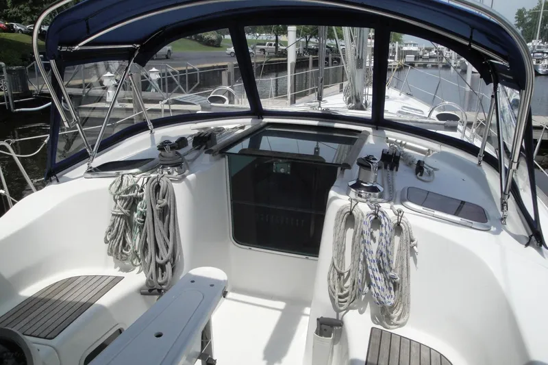 Slide: The Image of 2006 Beneteau Oceanis Clipper 423 cockpit with ropes and canopy in marina setting. - 32