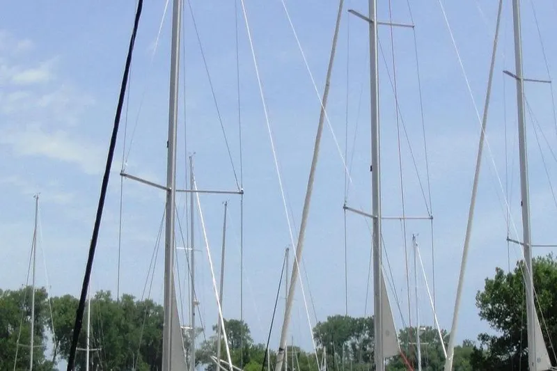Slide: The Image of Masts of a 2006 Beneteau Oceanis Clipper 423 sailboat against a clear sky. - 4
