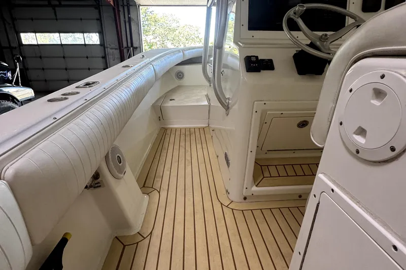 Slide: The Image of 2007 Regulator 32 Forward Seating boat interior with wood flooring and white seating. - 12