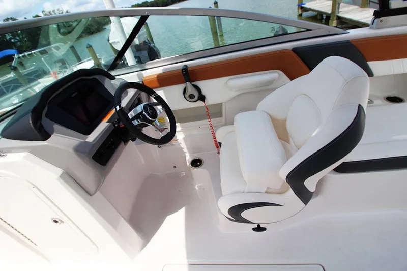 Slide: The Image of 2024 Chaparral 235 SSi OB boat interior with steering wheel and white seating. - 12