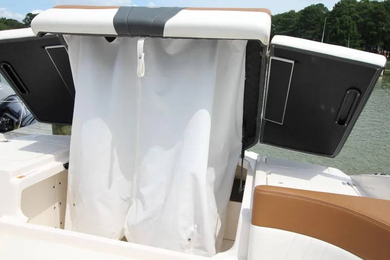 Slide: The Image of 2024 Chaparral 235 SSi OB boat with open storage compartment and white curtain. - 17