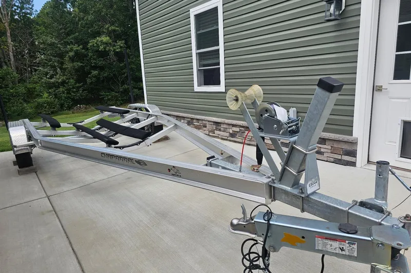 Slide: The Image of Trailer for 2024 Chaparral 235 SSi OB boat parked on concrete driveway. - 20