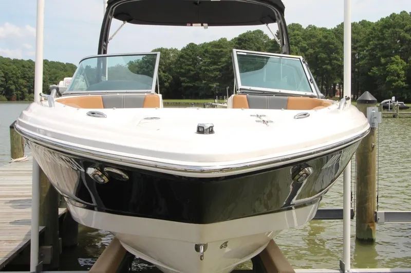 Slide: The Image of 2024 Chaparral 235 SSi OB boat docked on a sunny day by the lake. - 3