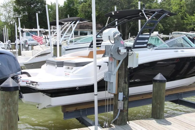 Slide: The Image of 2024 Chaparral 235 SSi OB boat docked at marina, featuring sleek design and modern amenities. - 4