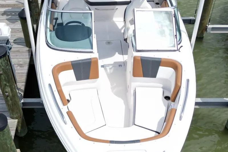 Slide: The Image of 2024 Chaparral 235 SSi OB boat with open bow seating, docked at a marina. - 5