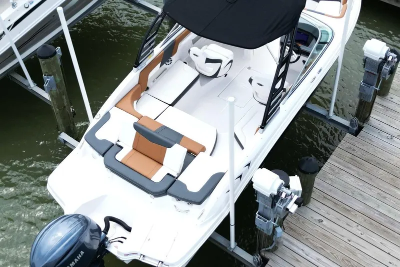 Slide: The Image of 2024 Chaparral 235 SSi OB boat docked, featuring sleek design and spacious seating. - 7