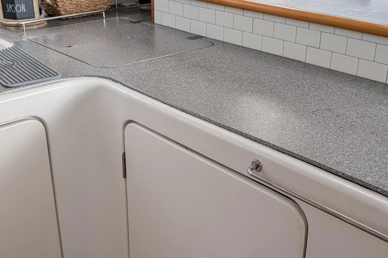 Slide: The Image of Kitchen countertop and cabinets in a 2001 Voyage 440 boat interior. - 10
