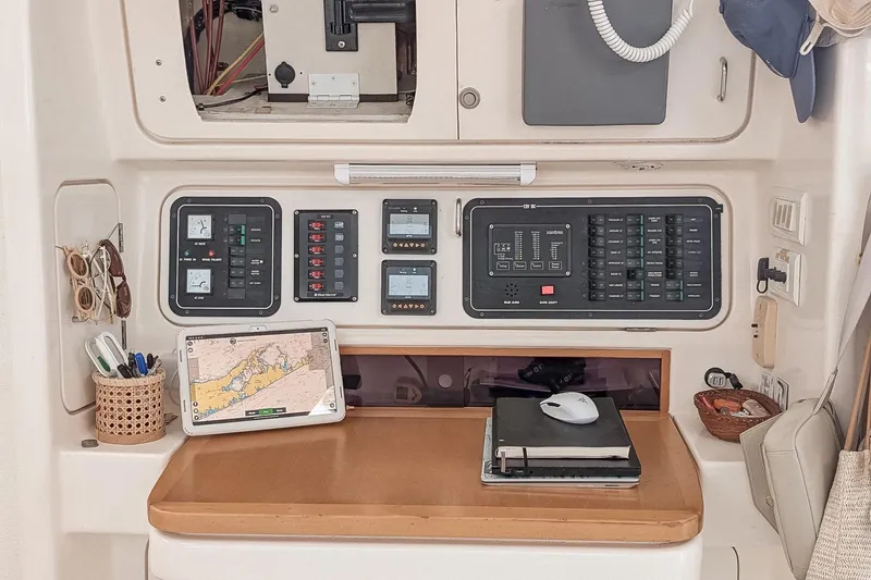 Slide: The Image of Navigation station on a 2001 Voyage 440 yacht with control panels and nautical charts. - 15