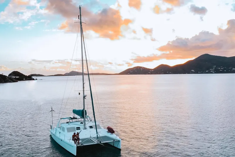 Slide: The Image of Sailing catamaran Voyage 440, 2001 model, at sunset on tranquil waters. - 2