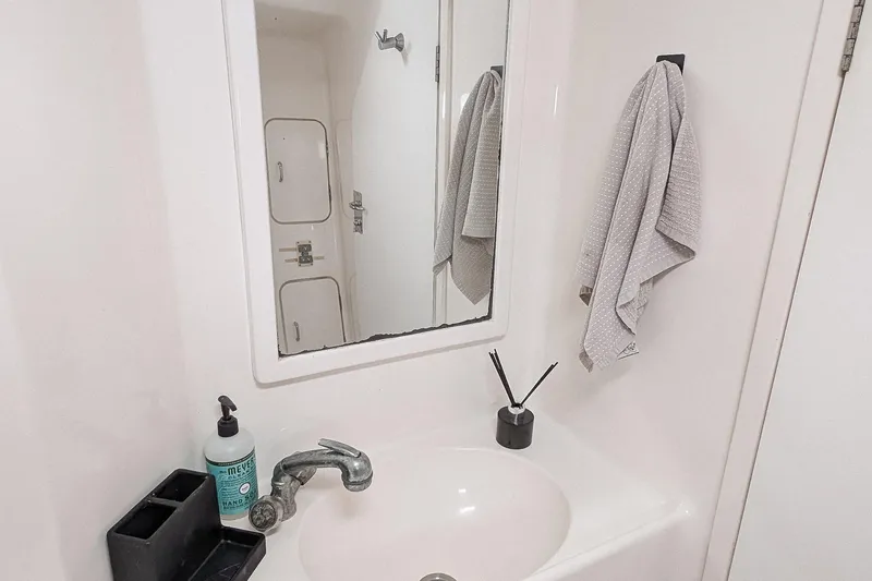 Slide: The Image of Bathroom sink area in 2001 Voyage 440 yacht with mirror, towel, and soap dispenser. - 21