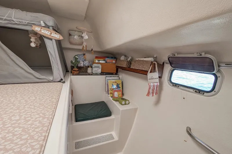 Slide: The Image of Cozy interior of 2001 Voyage 440 sailboat with nautical decor and window view. - 26