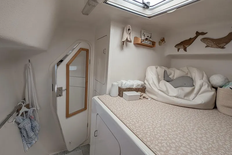 Slide: The Image of Cozy cabin interior of 2001 Voyage 440 yacht with bed, storage, and nautical decor. - 27