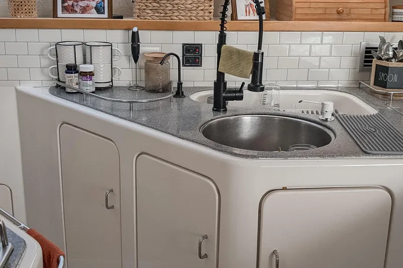 Slide: The Image of Compact kitchen area on a 2001 Voyage 440 yacht with modern sink and storage. - 9