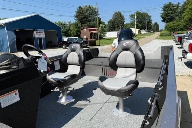 Slide: The Image of 2026 Crestliner 1650 Kodiak boat interior with two swivel seats, parked outdoors. - 7