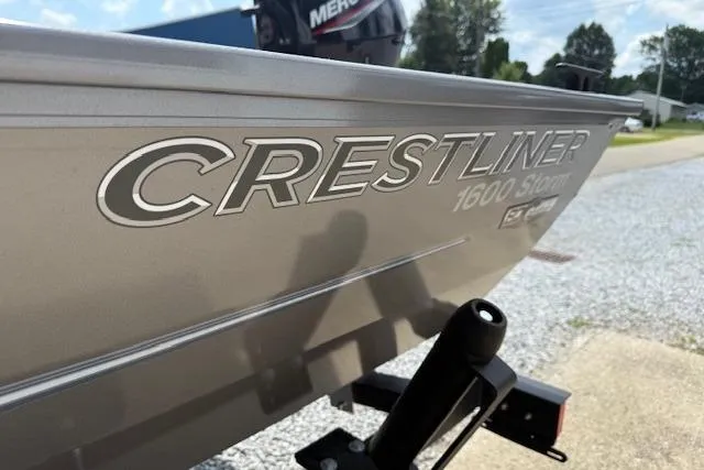 Slide: The Image of 2026 Crestliner 1600 Storm boat, side view with logo, parked outdoors. - 9