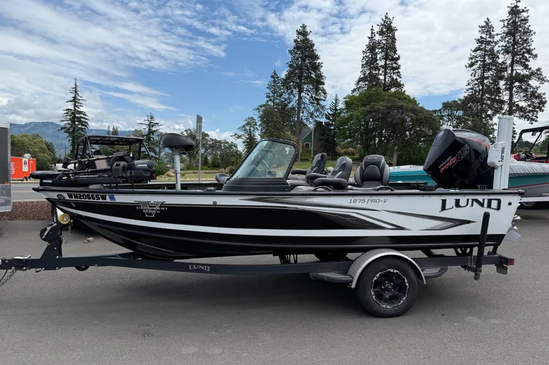 The Image of 2020 Lund 1875 Pro-V Sport fishing boat on trailer, parked outdoors. - 0
