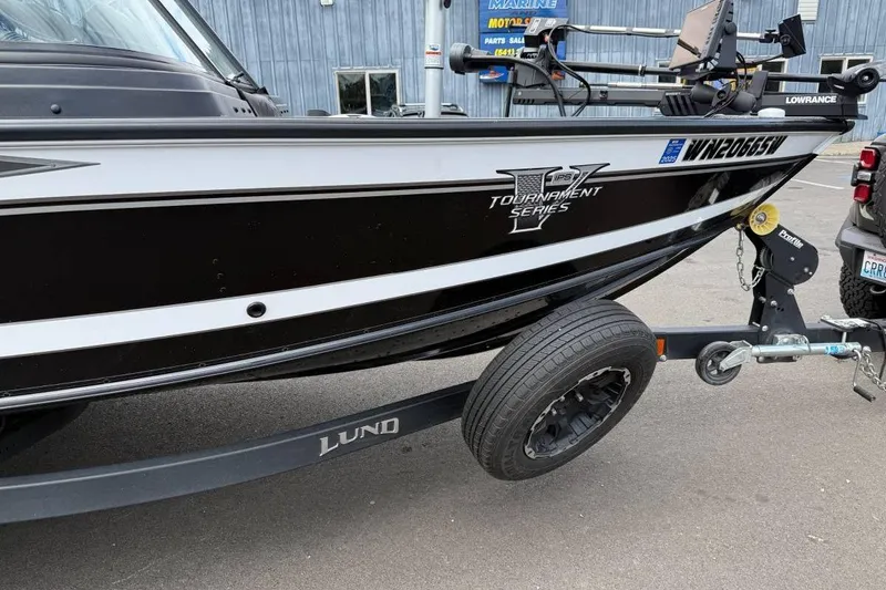 Slide: The Image of 2020 Lund 1875 Pro-V Sport boat on trailer, black and white design, parked outdoors. - 19