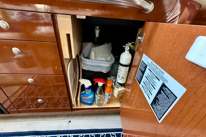 Slide: The Image of Cabinet storage on 2008 Sea Ray 340 Sundancer with cleaning supplies and fire extinguisher. - 100