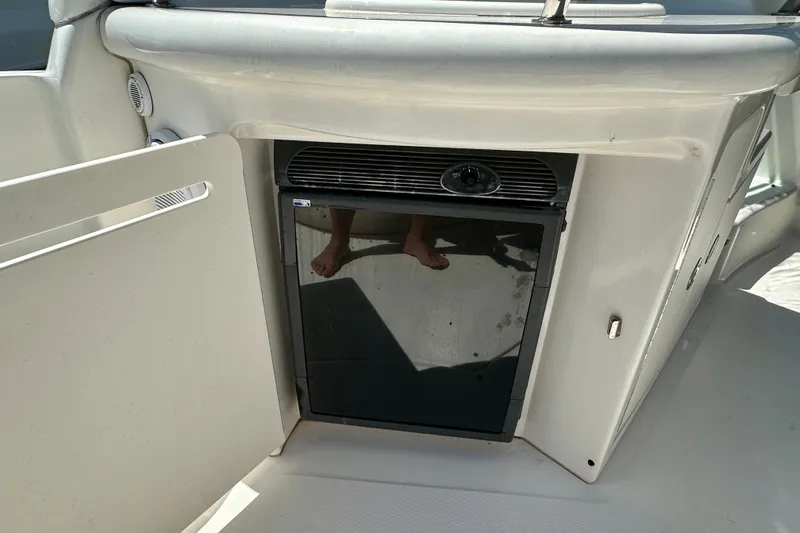Slide: The Image of 2008 Sea Ray 340 Sundancer boat interior with mini fridge and open cabinet. - 52