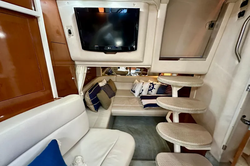 Slide: The Image of 2008 Sea Ray 340 Sundancer interior with TV, seating, and stairs. - 93