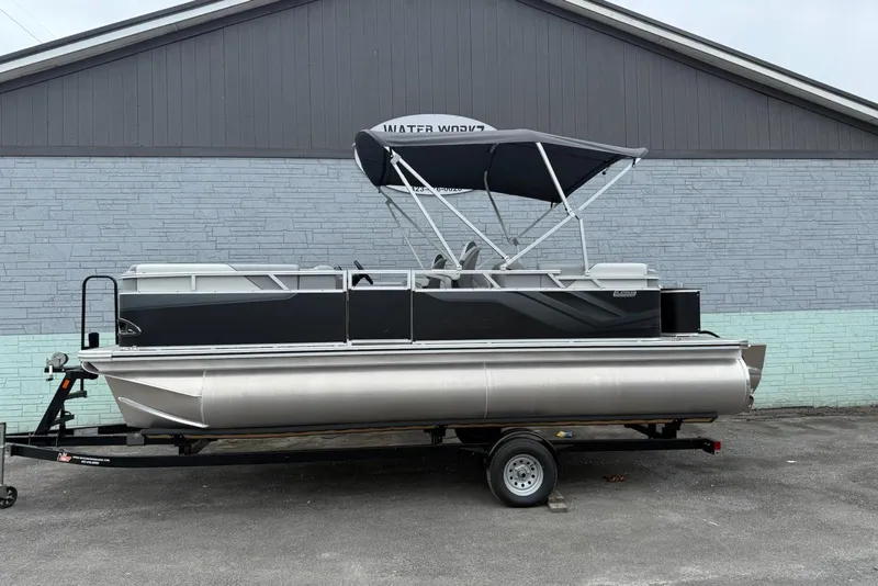 The Image of 2025 Avalon Venture Quad Lounger 2180 pontoon boat on trailer, parked outdoors. - 1
