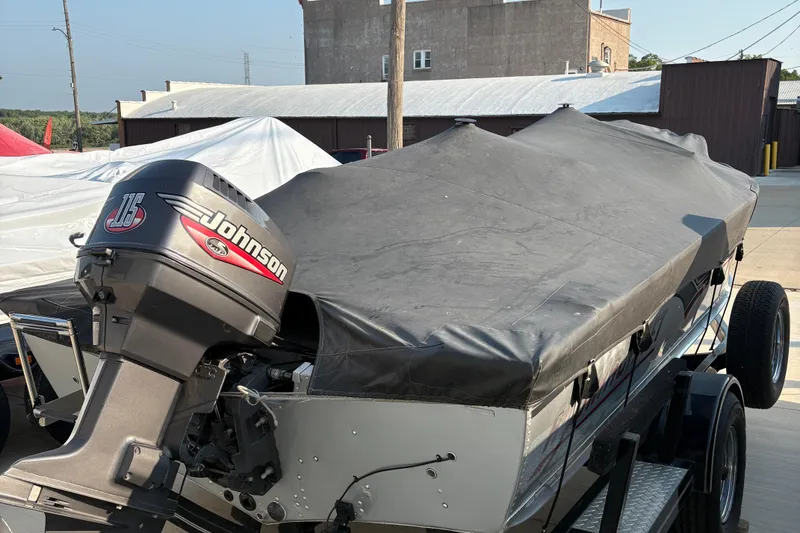 Slide: The Image of 1999 Alumacraft Tournament Pro 175 CS boat with Johnson 115 outboard motor, covered and on trailer. - 26