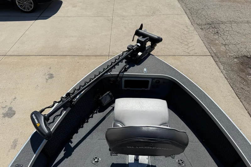 Slide: The Image of 1999 Alumacraft Tournament Pro 175 CS boat with trolling motor and seat, parked on concrete. - 8