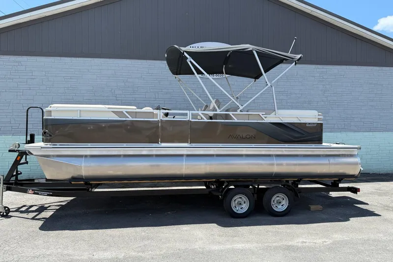 Slide: The Image of 2025 Avalon 2380 Venture Quad Lounger pontoon boat on trailer, side view. - 1