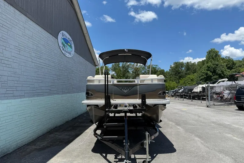 Slide: The Image of 2025 Avalon 2380 Venture Quad Lounger pontoon boat on trailer, outdoor dealership setting. - 2