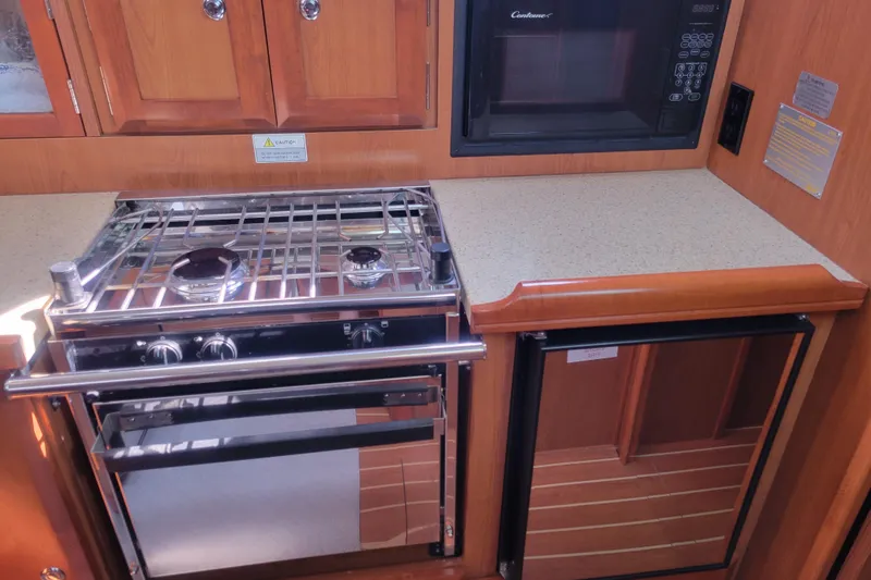 Slide: The Image of 2009 Hunter 38 yacht kitchen with stove, microwave, and compact fridge. - 23