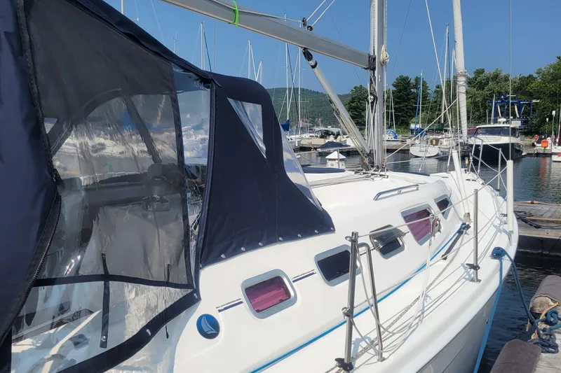 Slide: The Image of 2009 Hunter 38 sailboat docked at marina, featuring sleek design and protective canopy. - 41